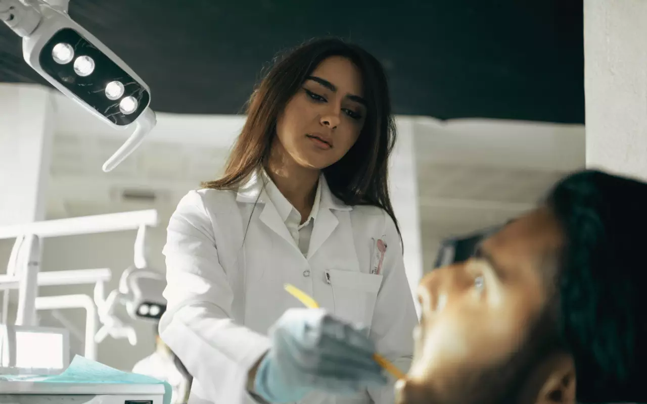 Odontóloga latina en su consultorio revisando agenda llena de nuevos pacientes captados mediante campañas de Google Ads y SEO local